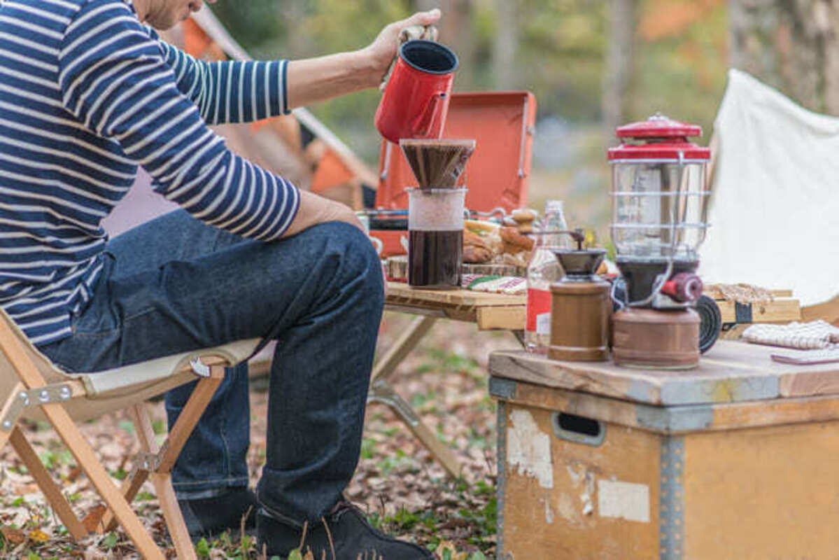 デイキャンプでコーヒーを楽しむ人