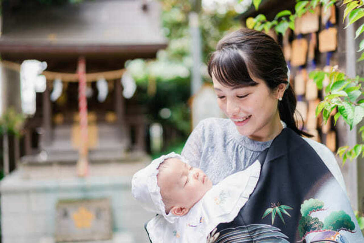 お宮参りをする母親と赤ちゃん