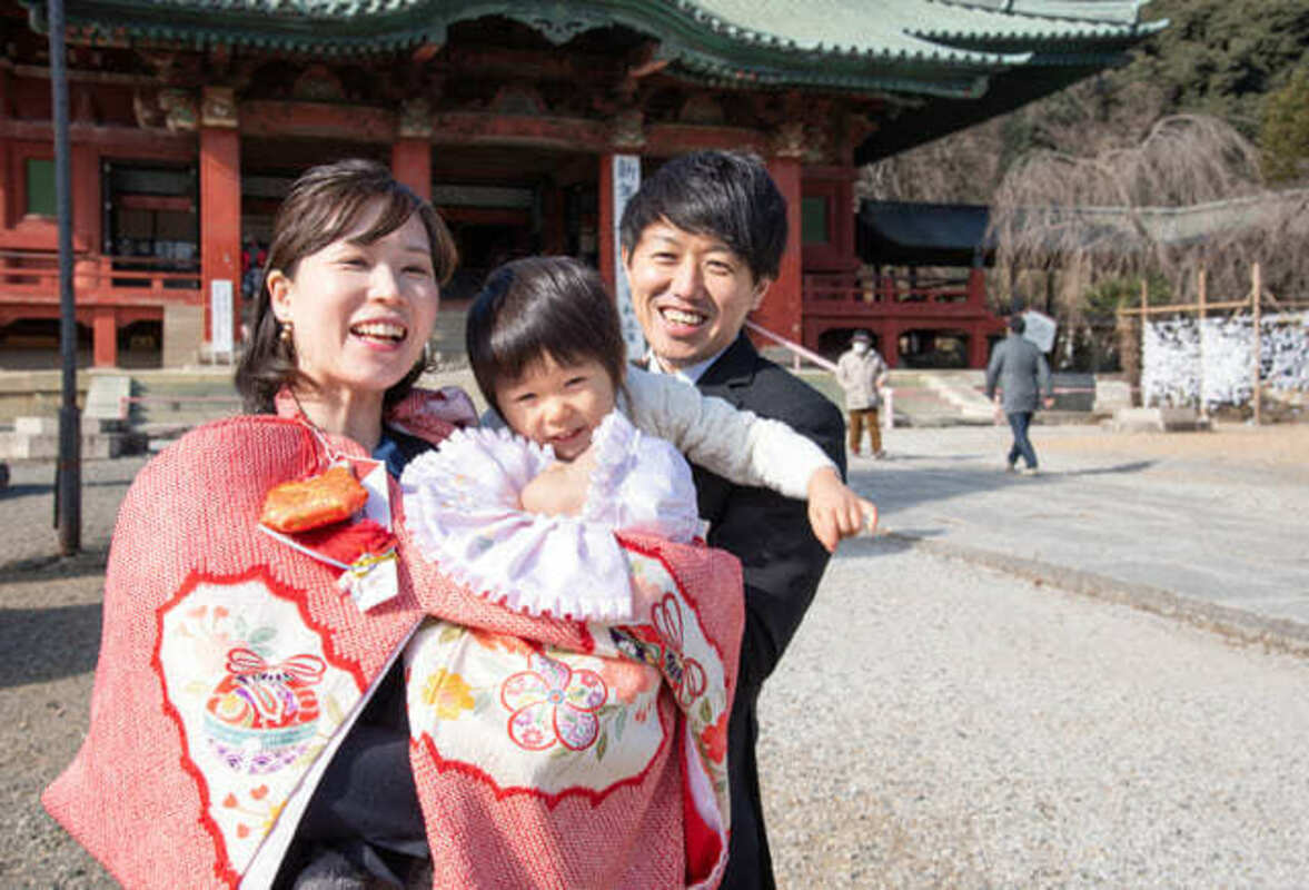 お宮参りをする3人家族