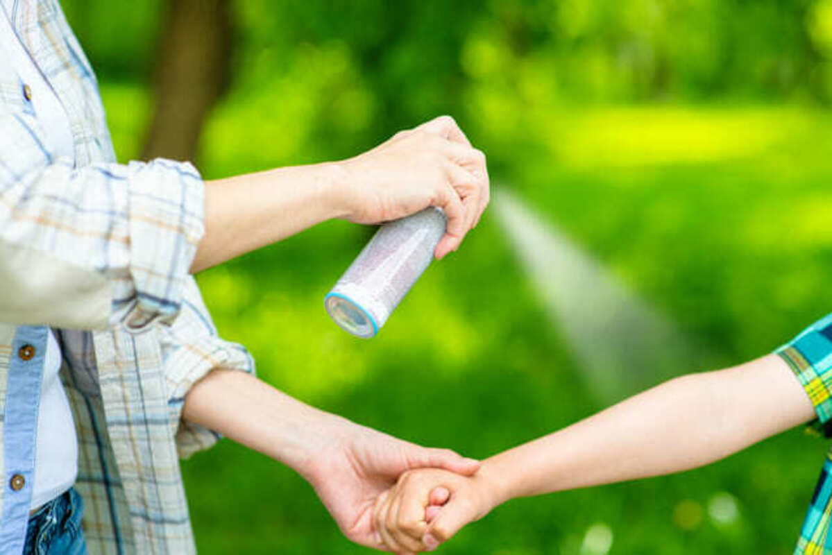 虫よけスプレーをかける人