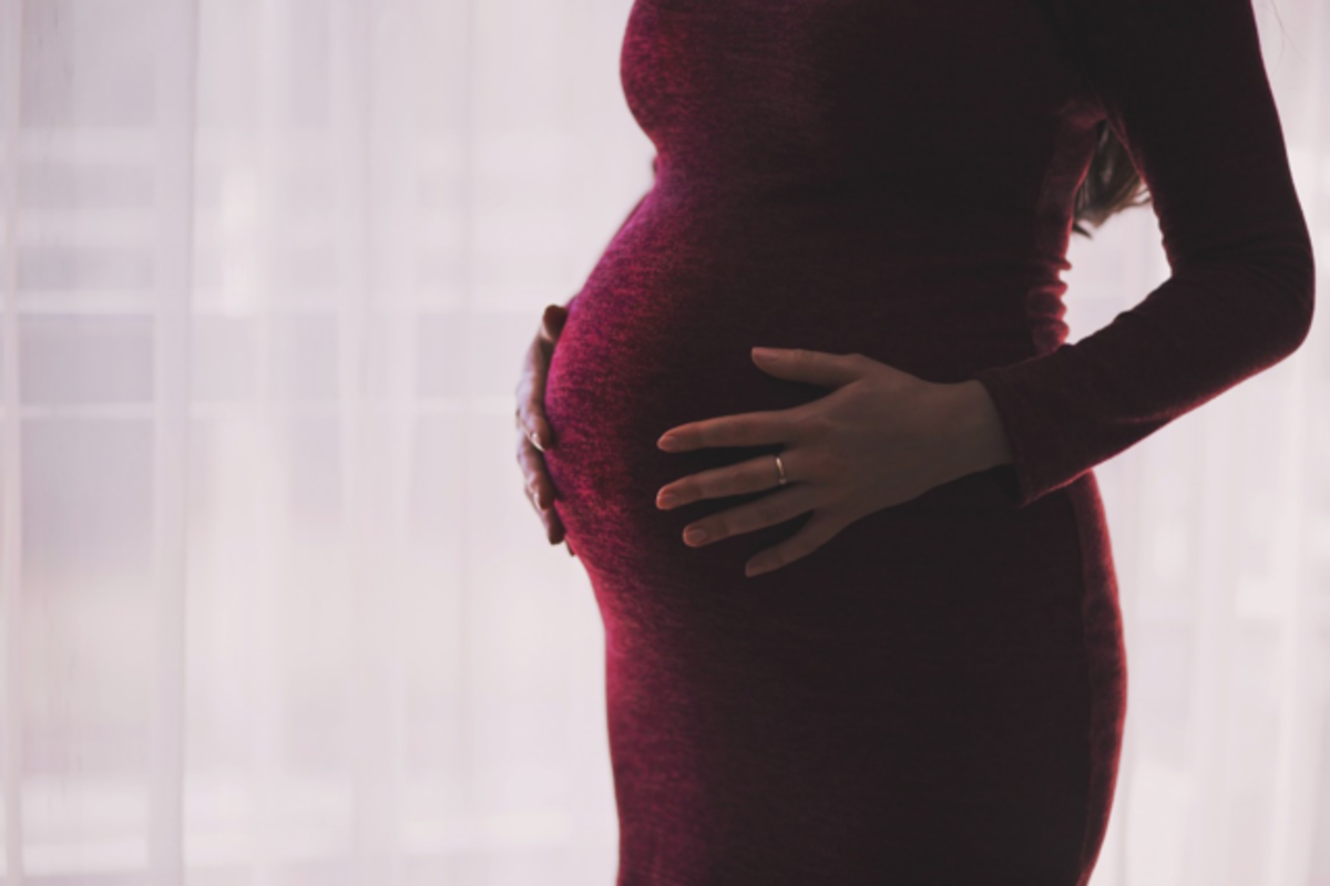 お腹に手を当てた妊婦の女性