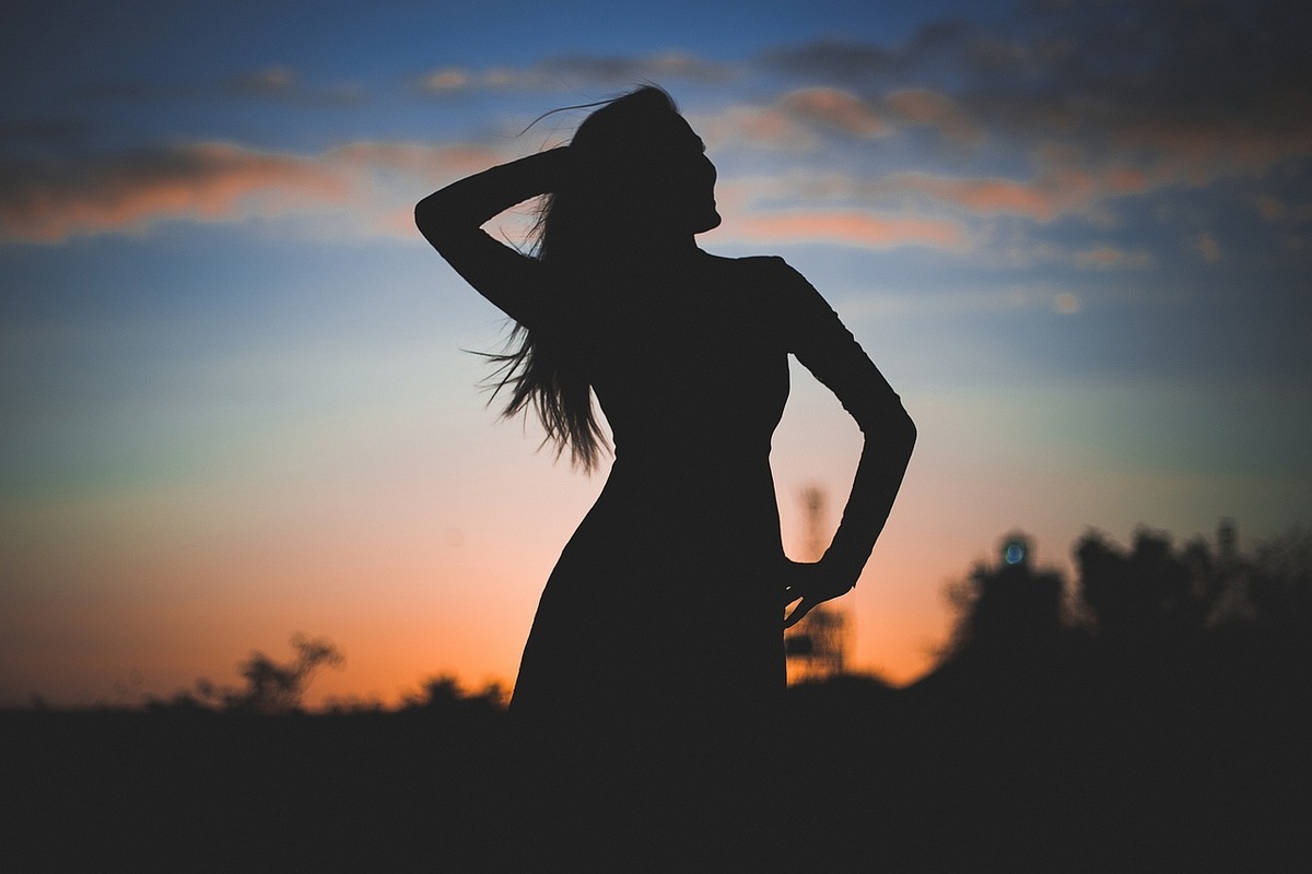夕日の前の女性