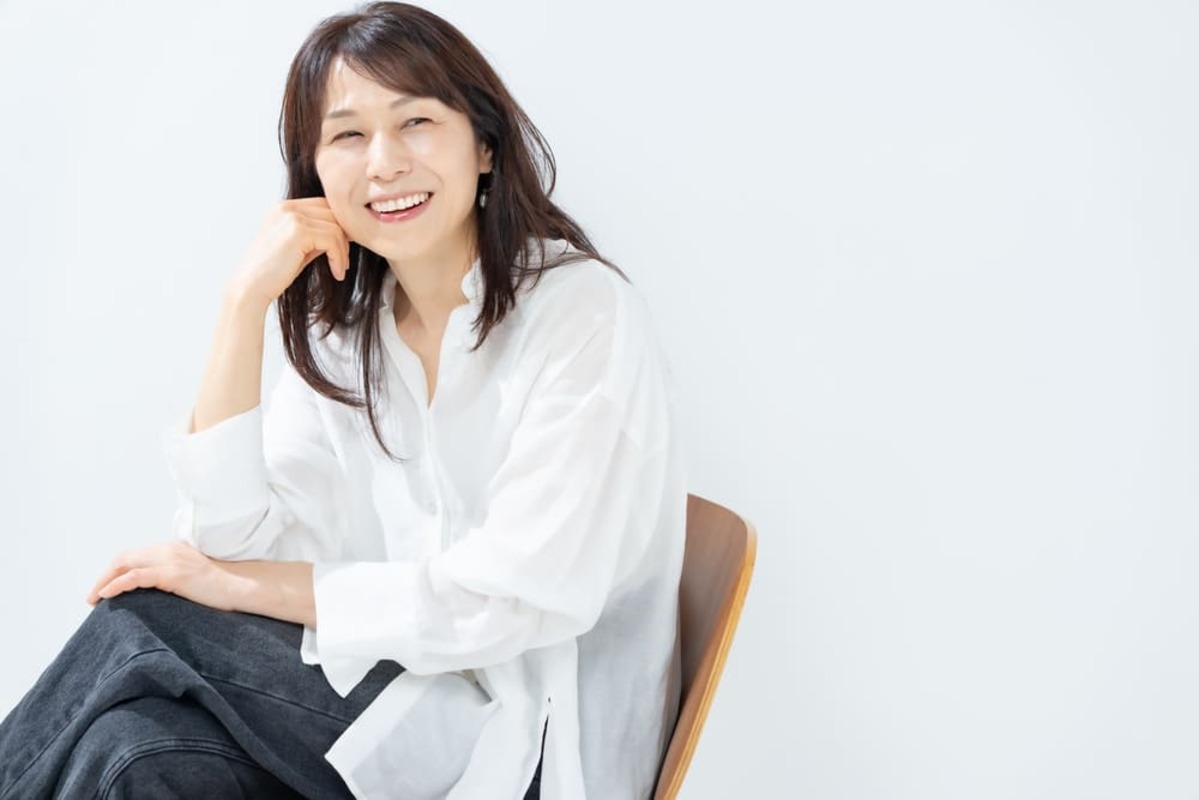 同窓会に参加して会話する60代女性