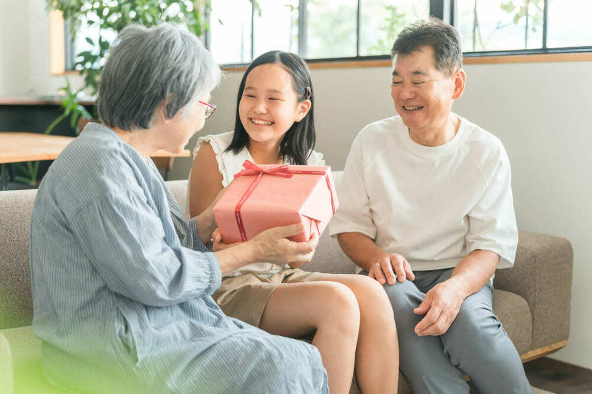 孫に誕生日プレゼントを渡す祖母