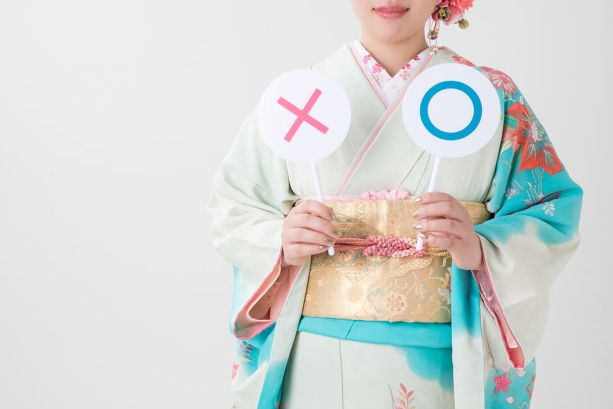 初詣 いつまで  マルバツを持つ振袖の女性