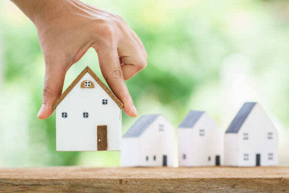 家のオブジェを持ち上げる人