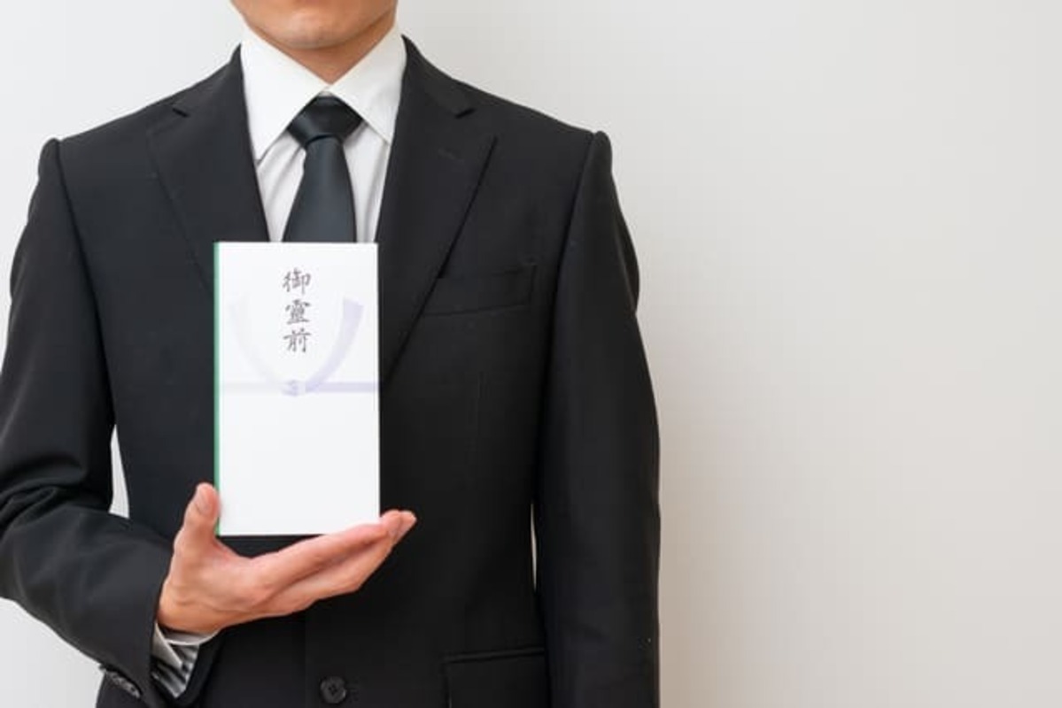 御霊前を持った男性