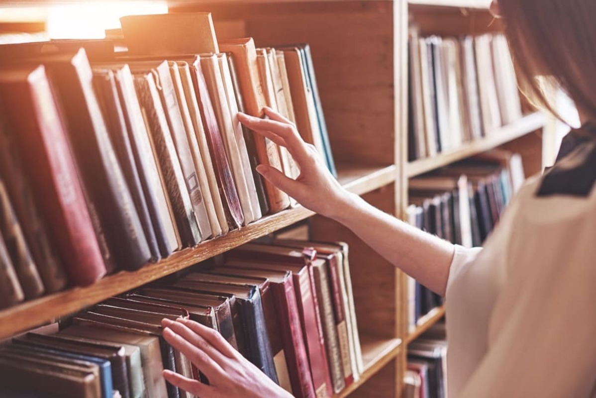 図書館で本を探す女性
