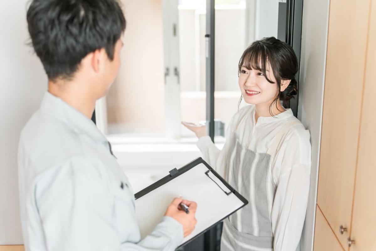 リフォーム業者の人と話をする女性