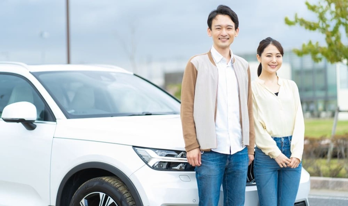 車の前に立つ夫婦