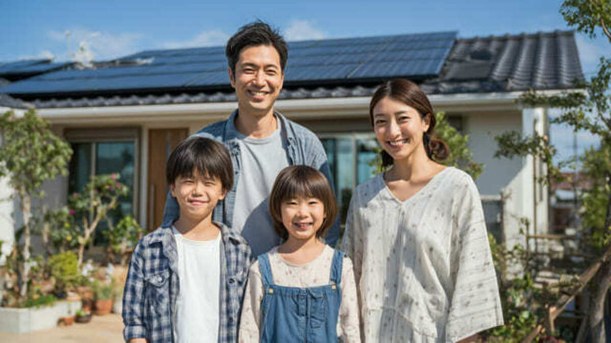 ソーラーパネルを取り付けた家に住んでいる家族