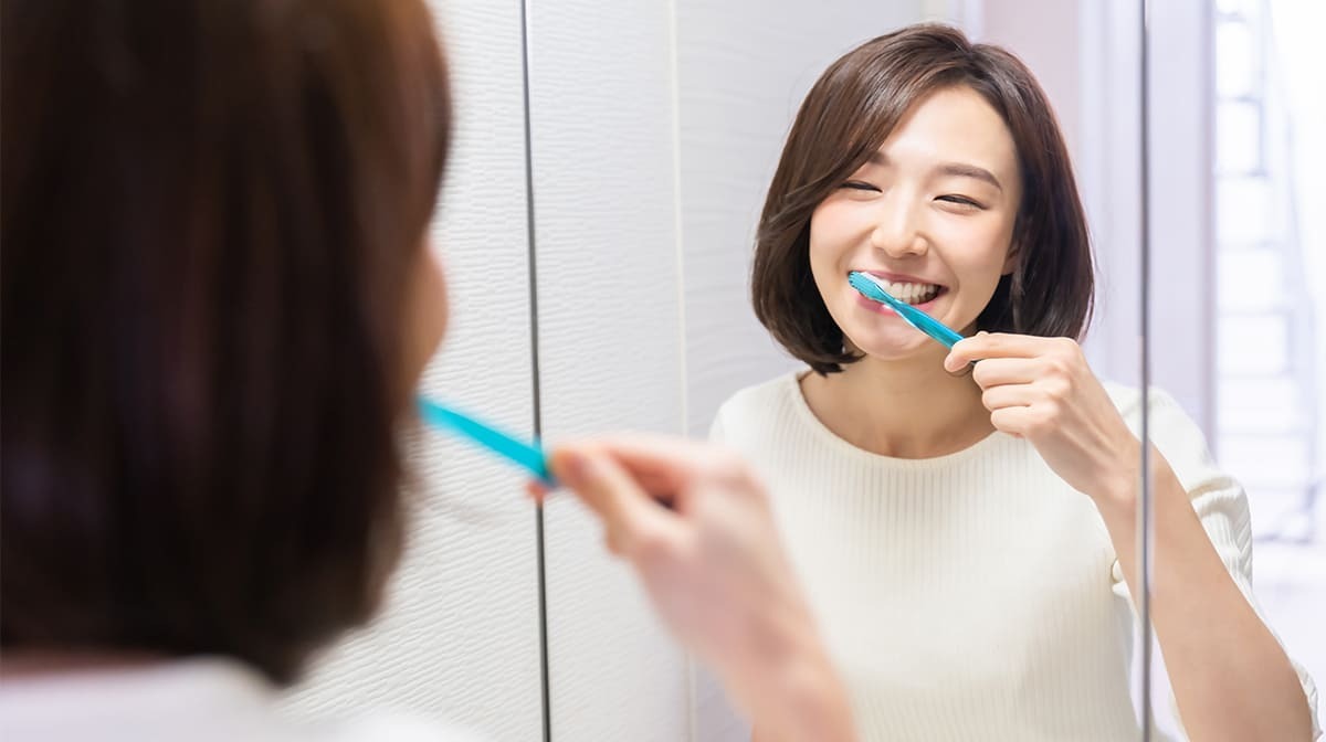 見出し画像 鏡を見ながら歯を磨く女性