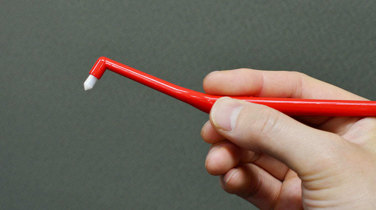 ワンタフトブラシを手に持っている